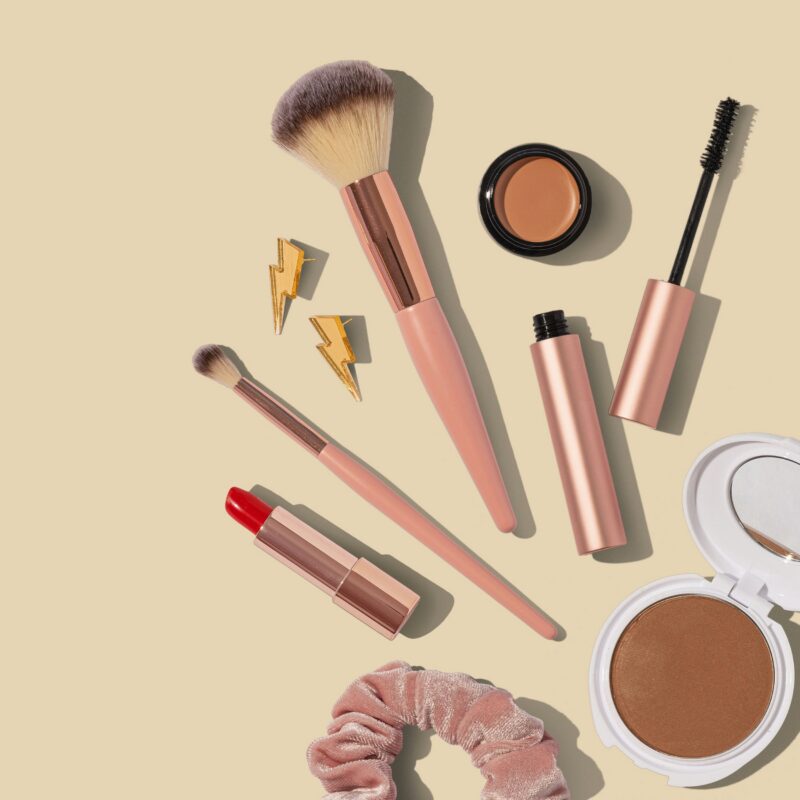 Professional makeup artist's kit laid out showing brushes, foundation range, and essential products